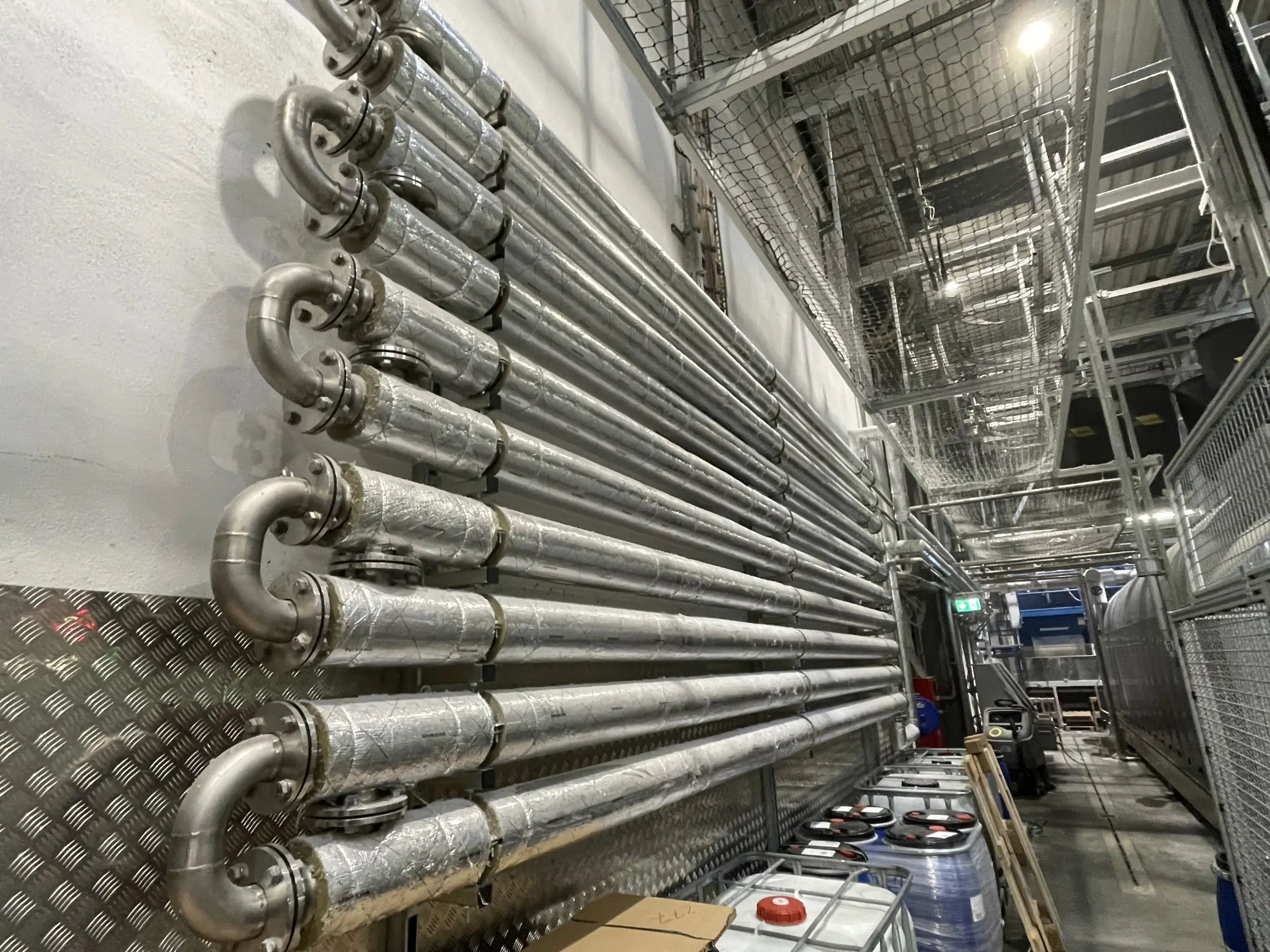 Abwasserwärmetauscher mit parallelem Rohrsystem in einer industriellen Wäscherei, seitliche Ansicht