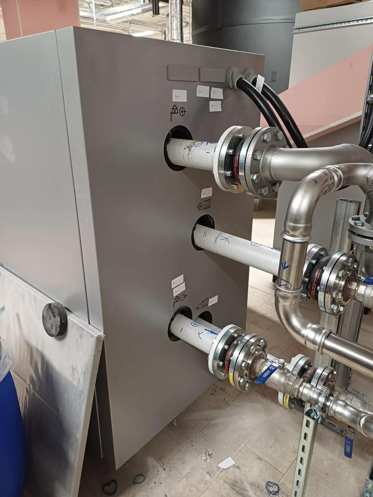 Industriewärmepumpe mit Rohranschlüssen in einer industriellen Wäscherei